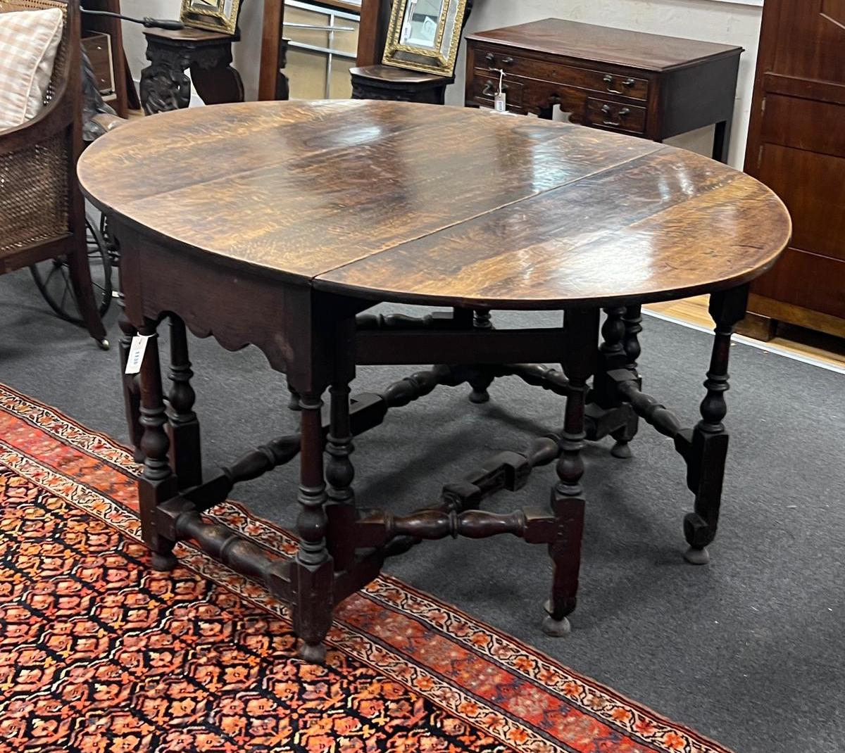 An 18th century oval oak gateleg dining table with turned under frame, width extended 146cm, depth 114cm, height 74cm